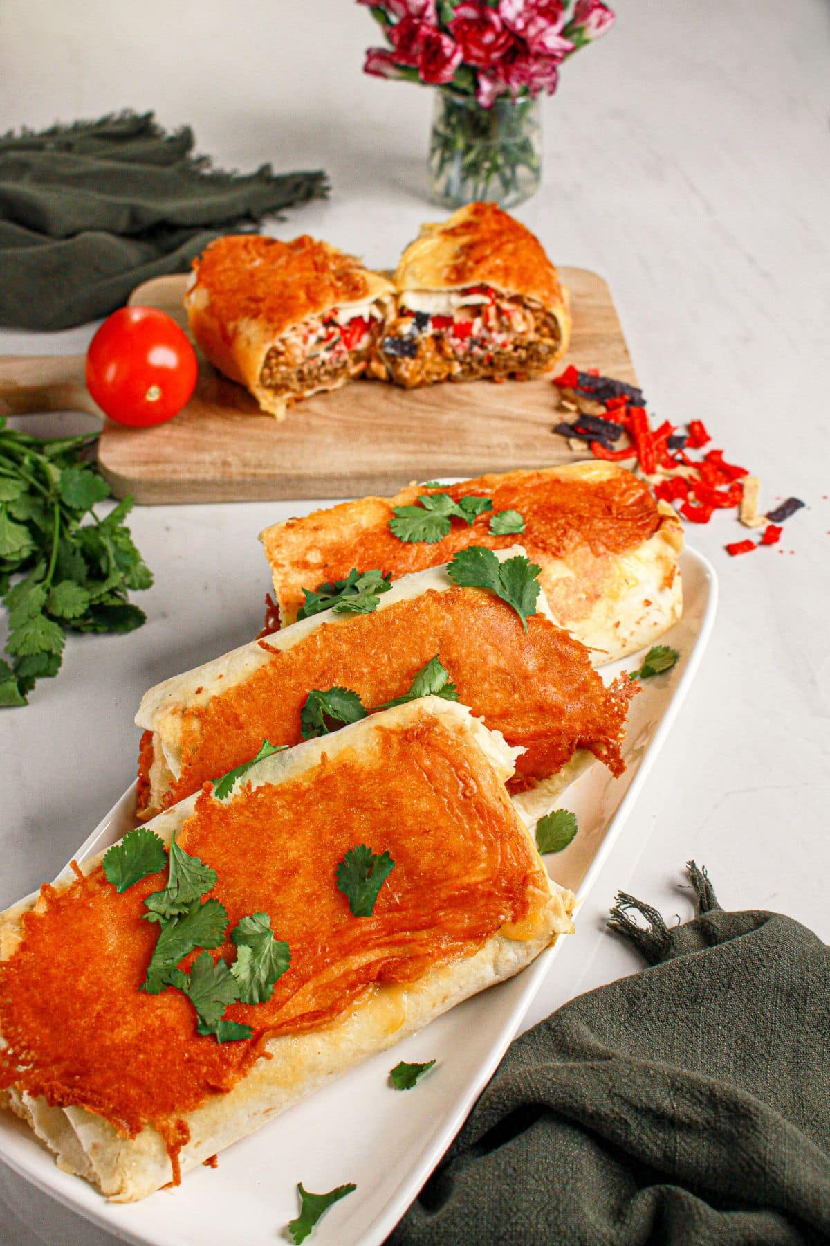 Three grilled cheese burritos on a serving platter.