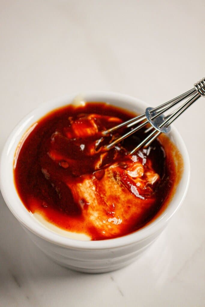 Sauce being whisked in a small bowl.