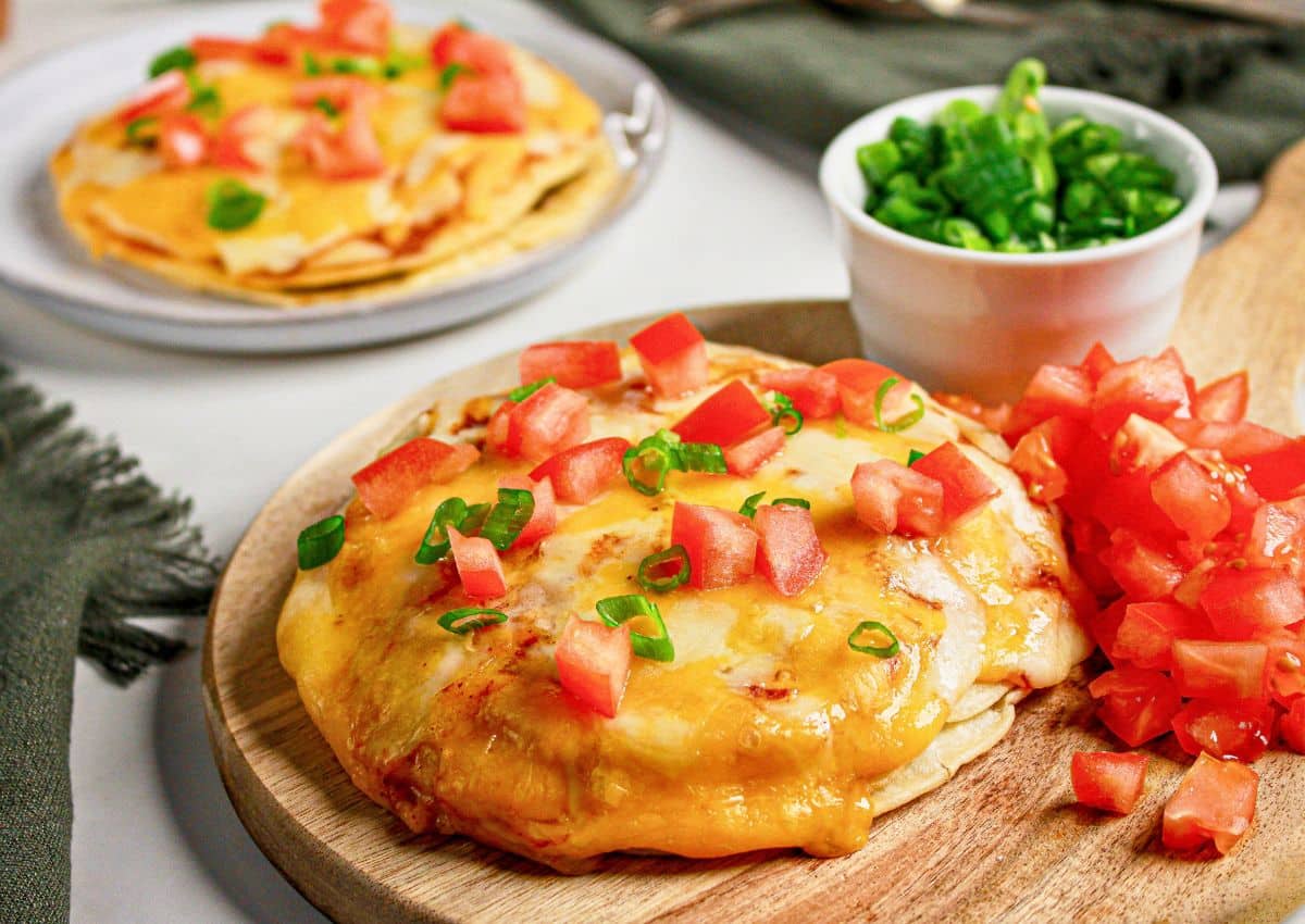 Mexican pizza on a wooden cutting board.
