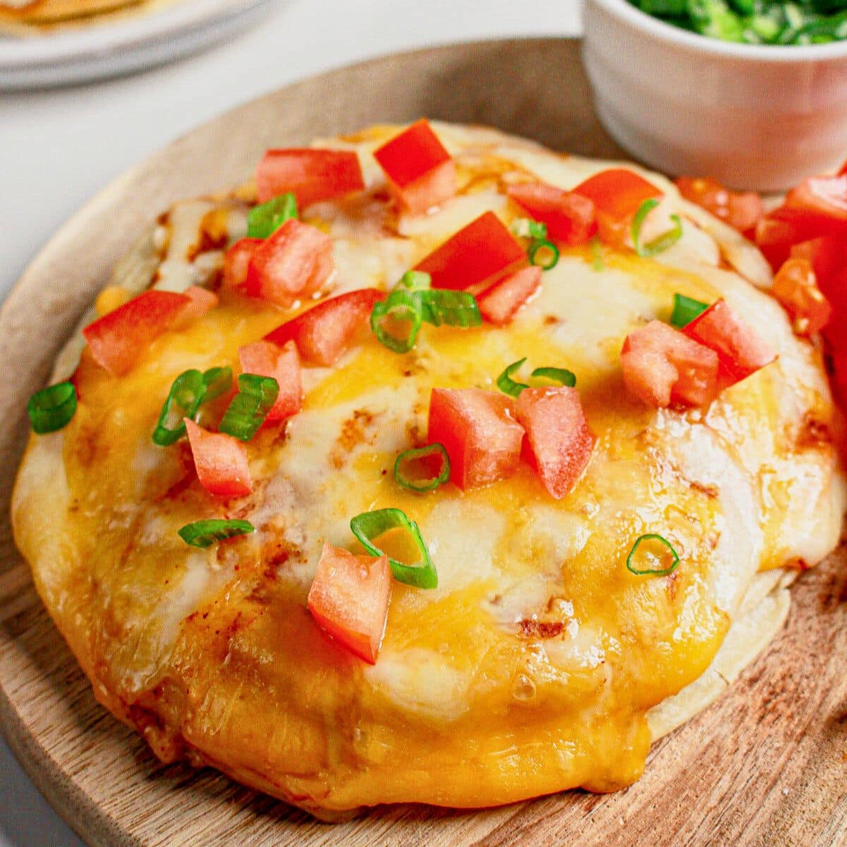Mexican pizza on a wooden cutting board.