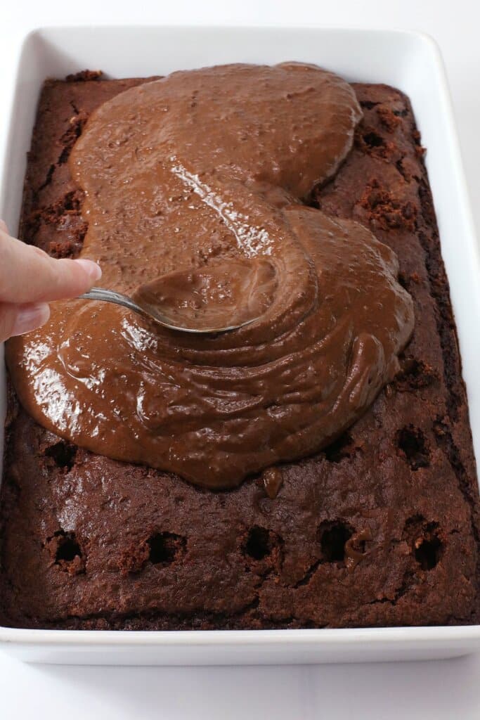 Chocolate pudding being spread on top of dessert.