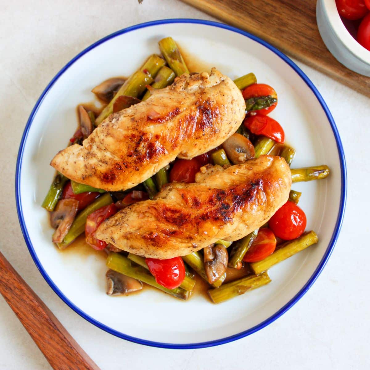 Chicken tenderloins on top of a bed of vegetables.