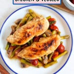 Chicken tenderloins on top of a bed of vegetables.