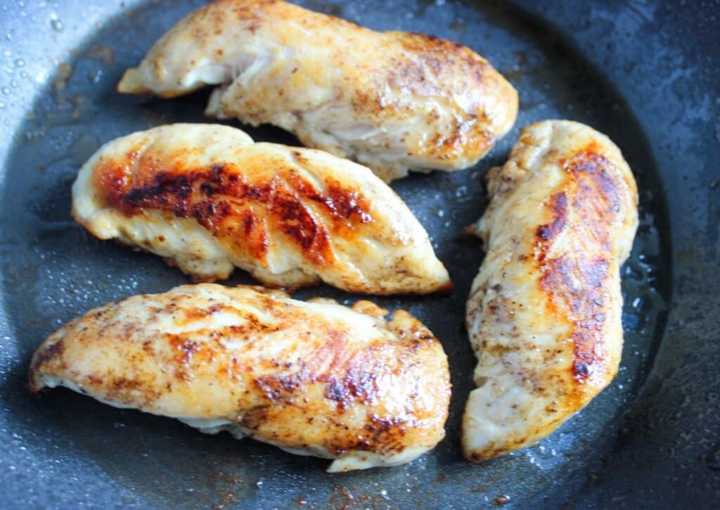 Tenderloins being cooked in a skillet.