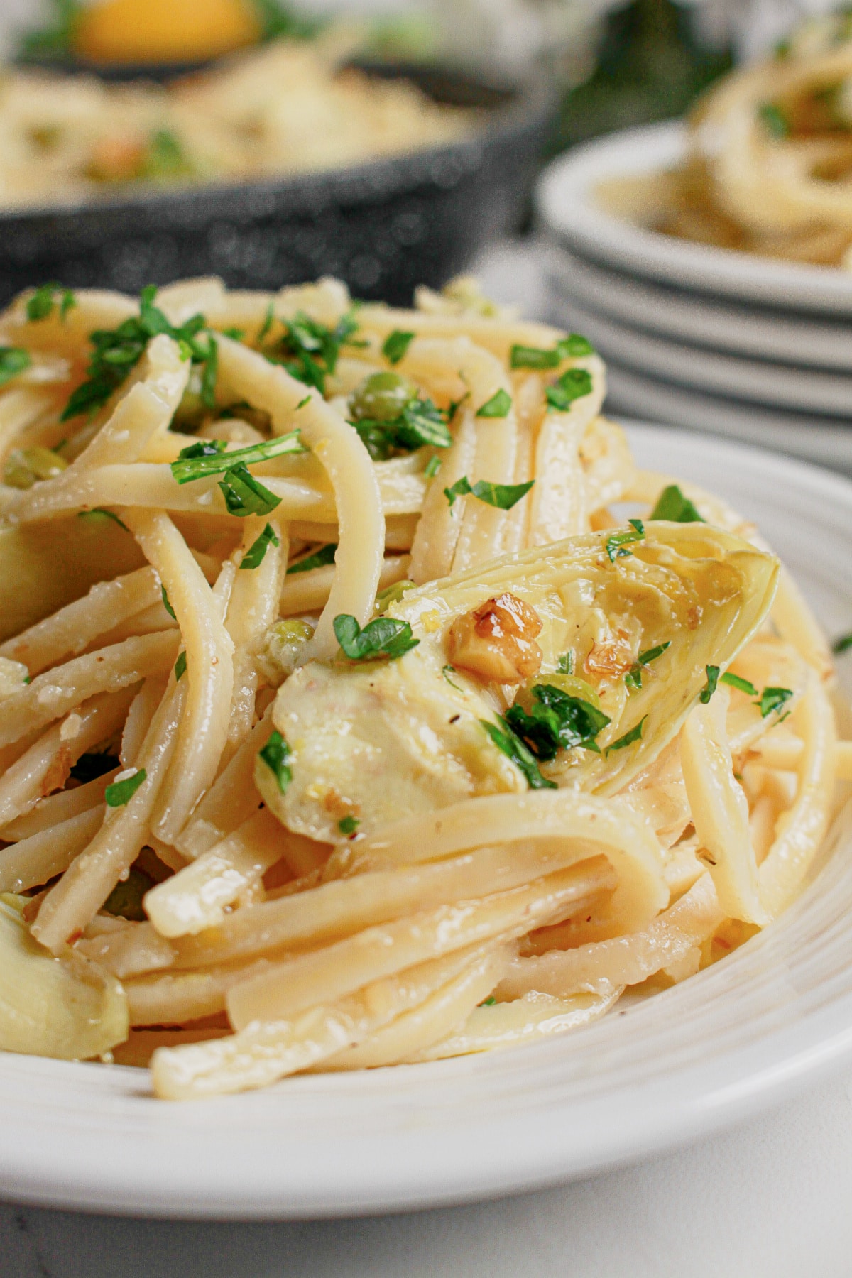 Small plate full of pasta with artichokes.