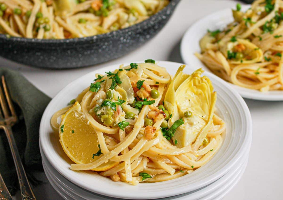 Small plate full of pasta with artichokes.