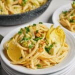 Small plate full of pasta with artichokes.