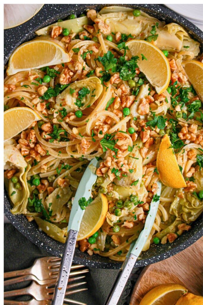 Skillet full of pasta, peas, lemons, and artichokes.