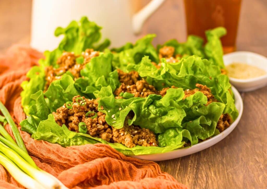 Ground chicken lettuce boats on a white plate.