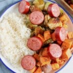Sheet Pan Kielbasa and Veggies White plate full of sausage, veggies, and rice.