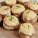Stuffed Mushrooms with Cream Cheese Cream cheese stuffed mushrooms on a wooden cutting board.