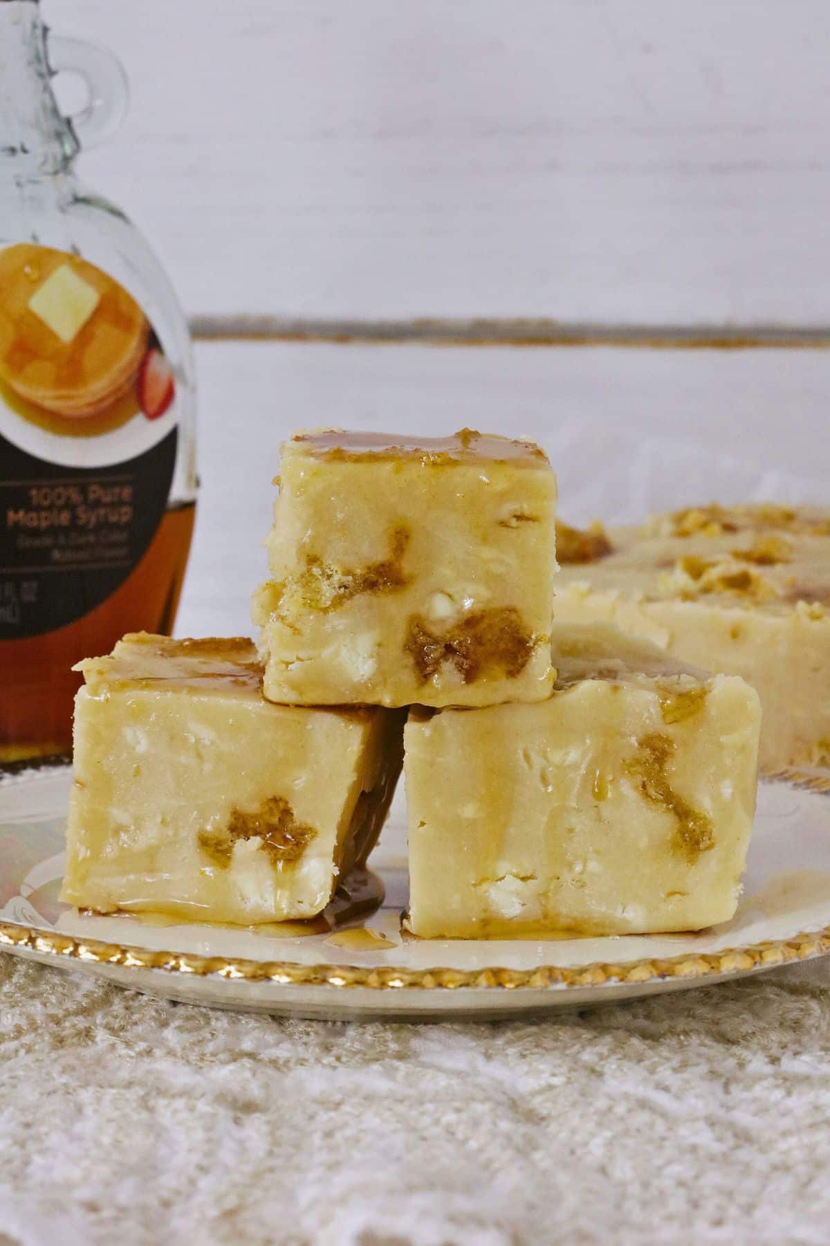 Three pieces of fudge on a white and gold plate.