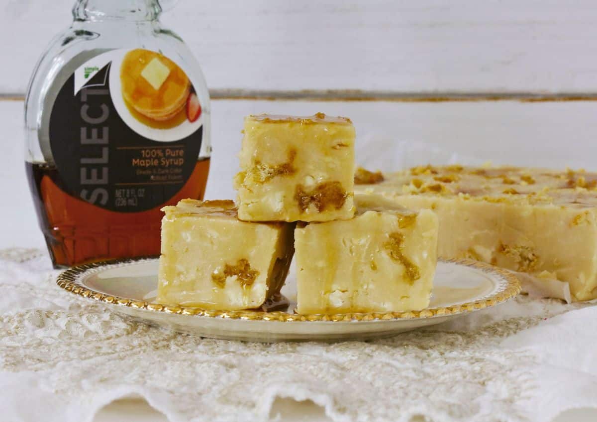 Three pieces of fudge on a white and gold plate.