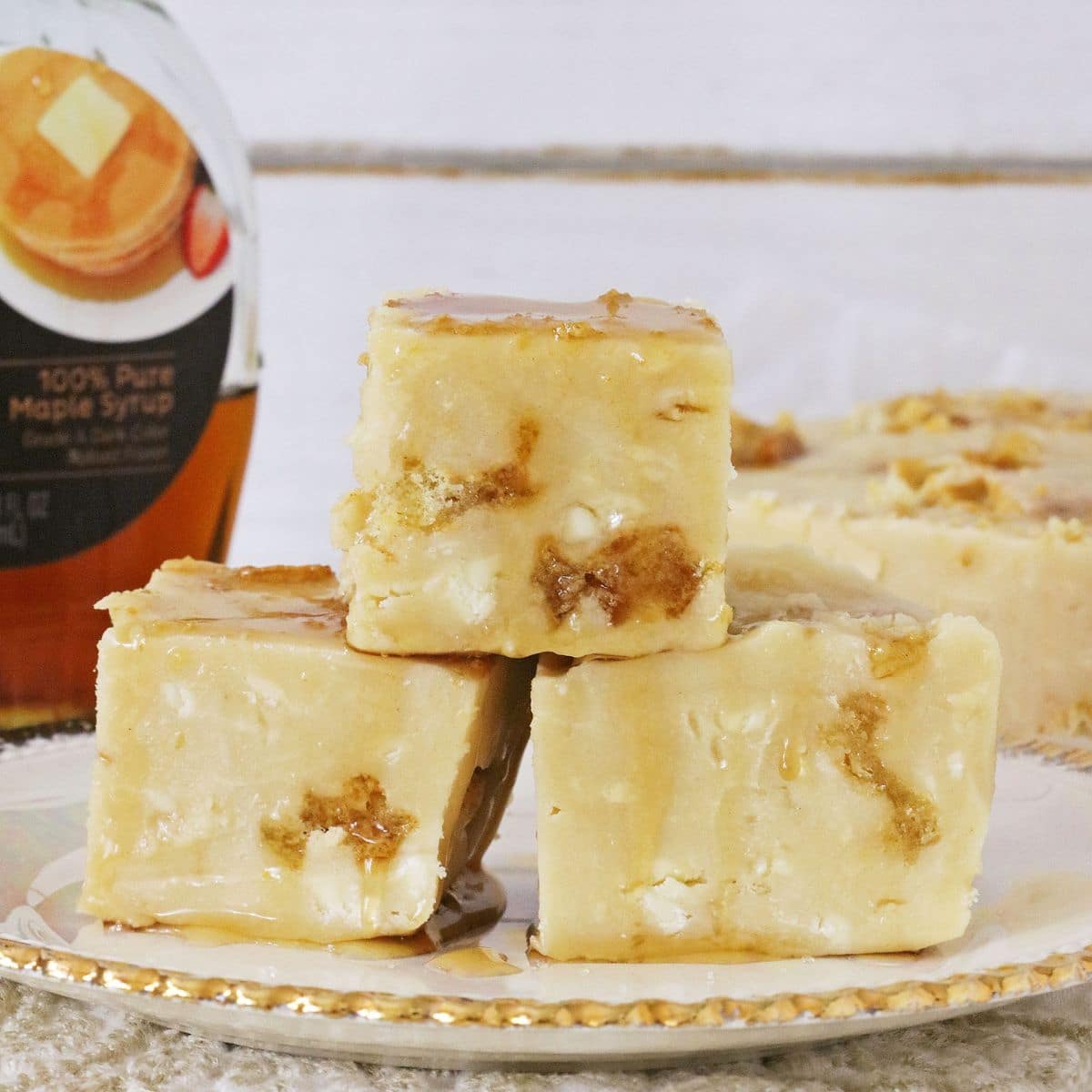 Three pieces of fudge on a white and gold plate.