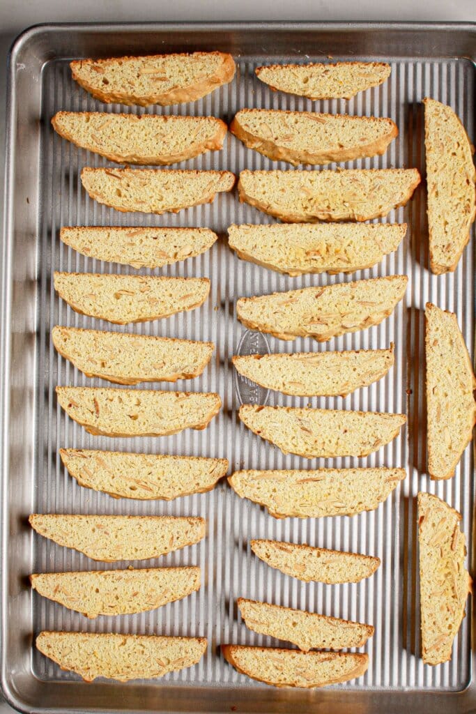 Slices of cookies on a baking sheet are cooling.