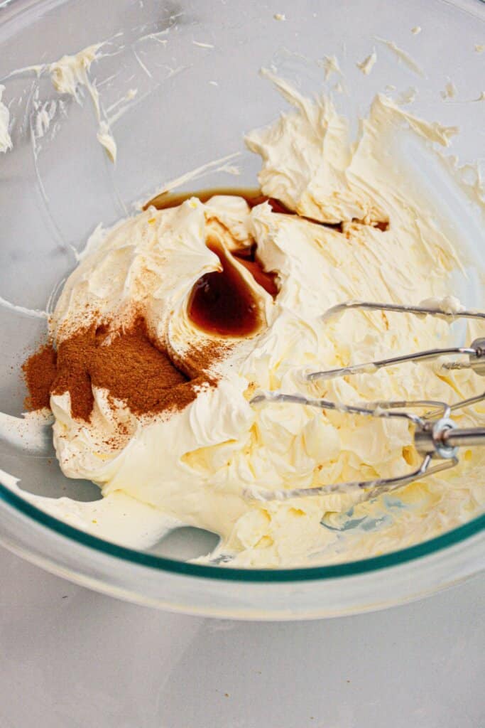 Cinnamon and vanilla being added to frosting.
