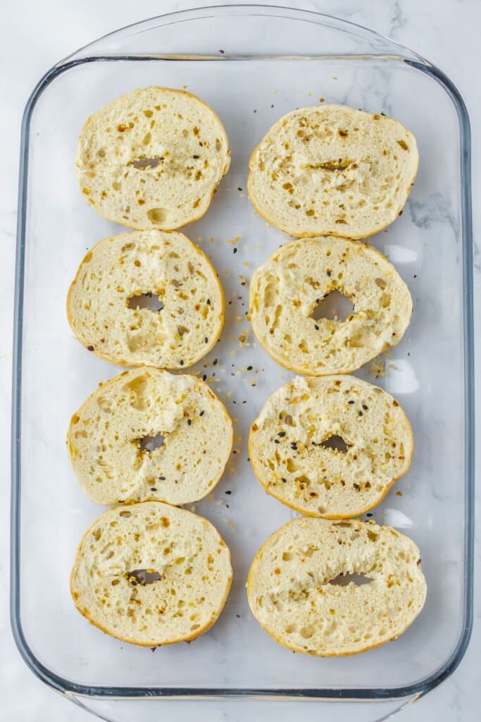 Bagel bottoms in a glass baking dish.