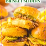 Three brisket sliders stacked on a plate.