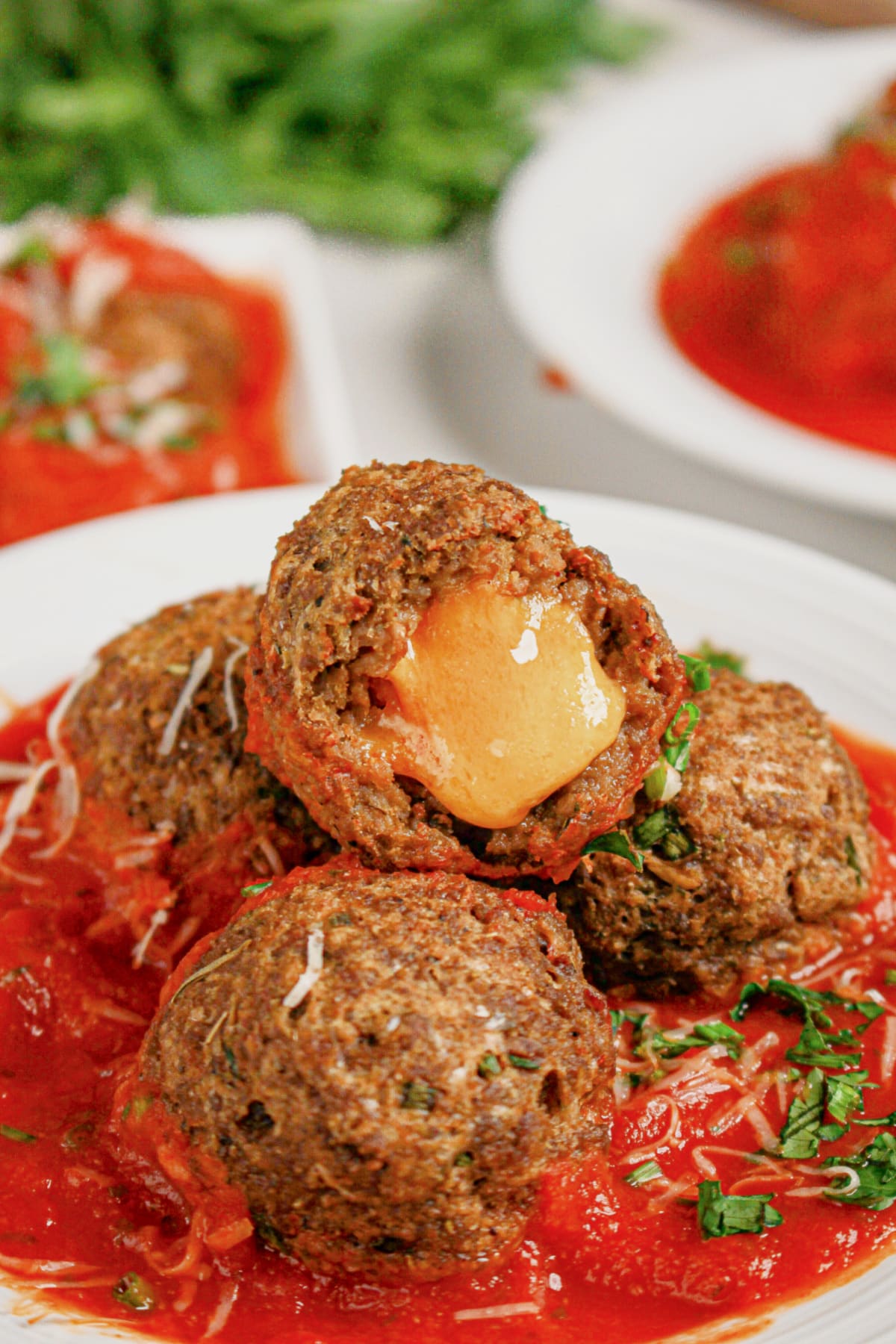 Cheese stuffed meatballs on a white plate.