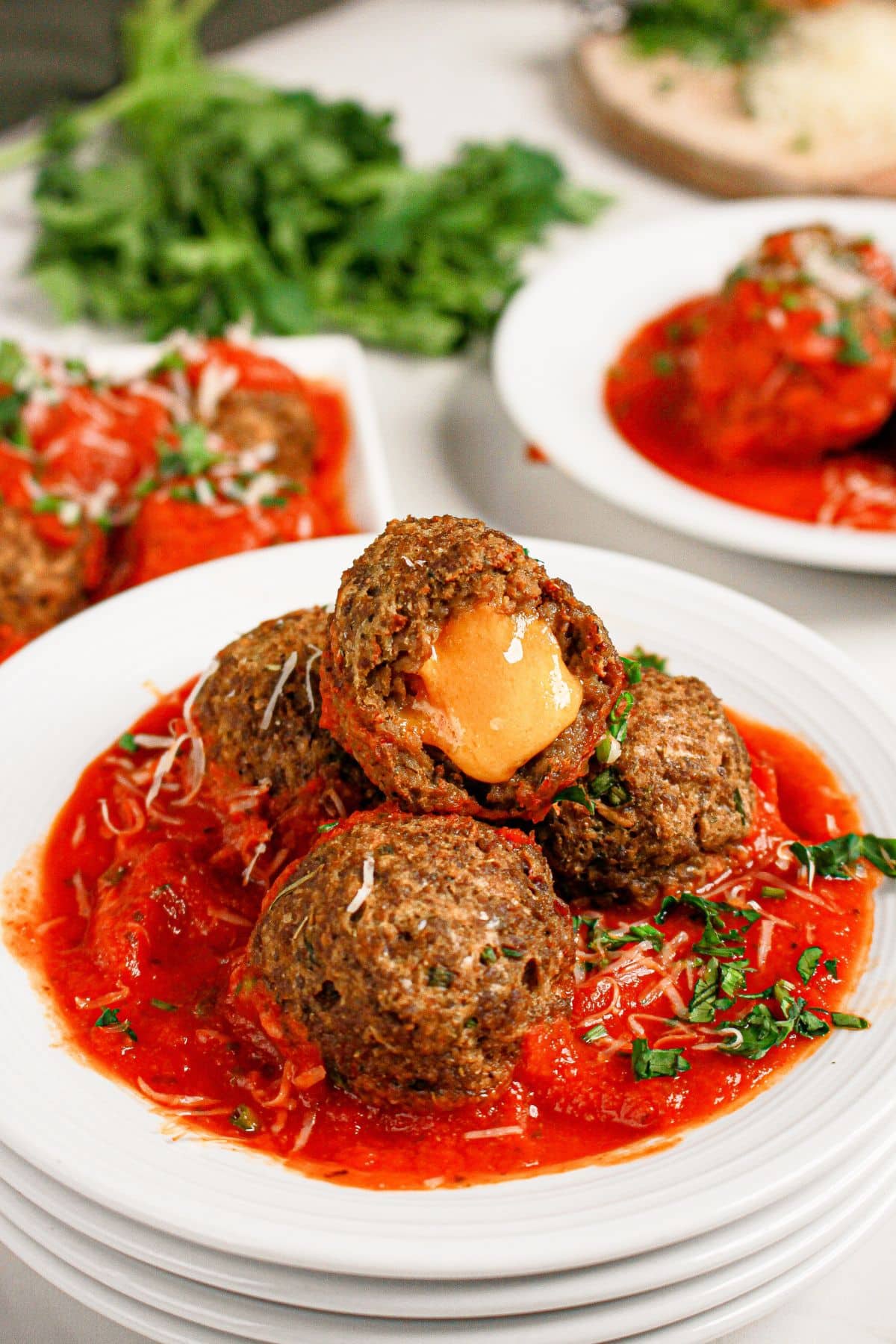 Cheese stuffed meatballs on a white plate.