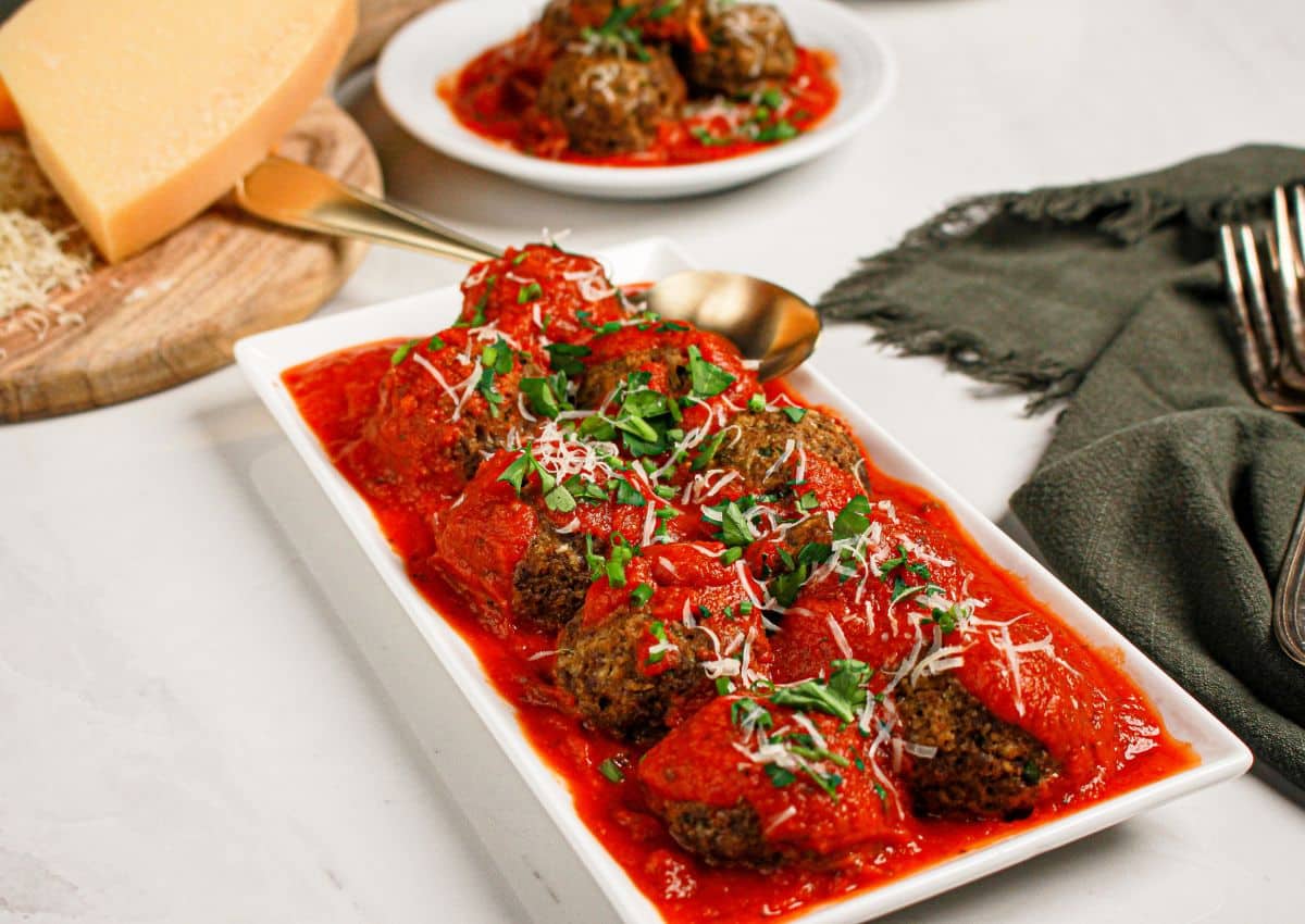 Cheese stuffed meatballs on a white plate.