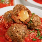 Cheese Stuffed Meatballs Cheese-stuffed meatballs on a white plate.