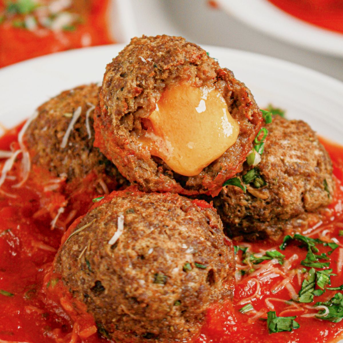 Cheese-stuffed meatballs on a white plate.