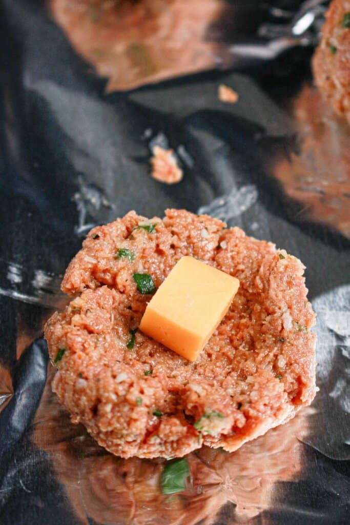 Beef being wrapped around a piece of cheese.