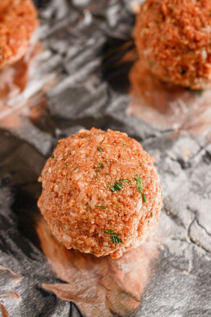 Raw meat on a foil lined baking sheet.