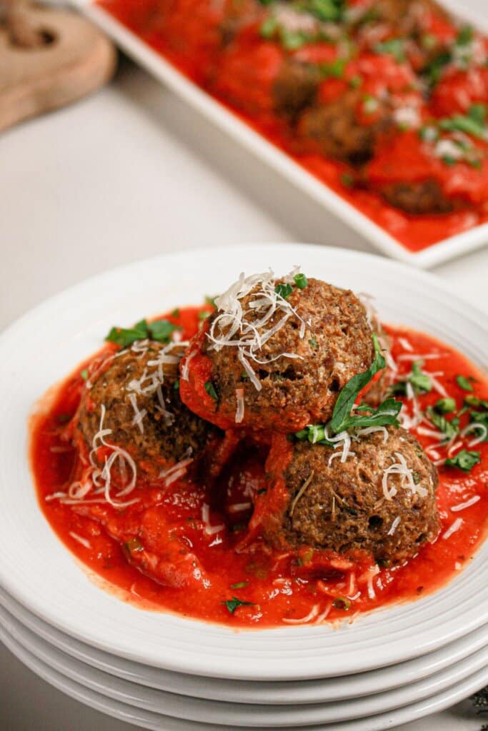 Cheese stuffed meatballs on a white plate.