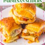 Three chicken parmesan sliders stacked on a plate.