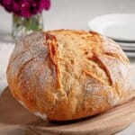Easy Sourdough Bread Whole sourdough bread loaf on a wooden cutting board.