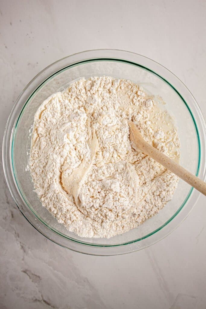 Dough being mixed in a glass bowl.