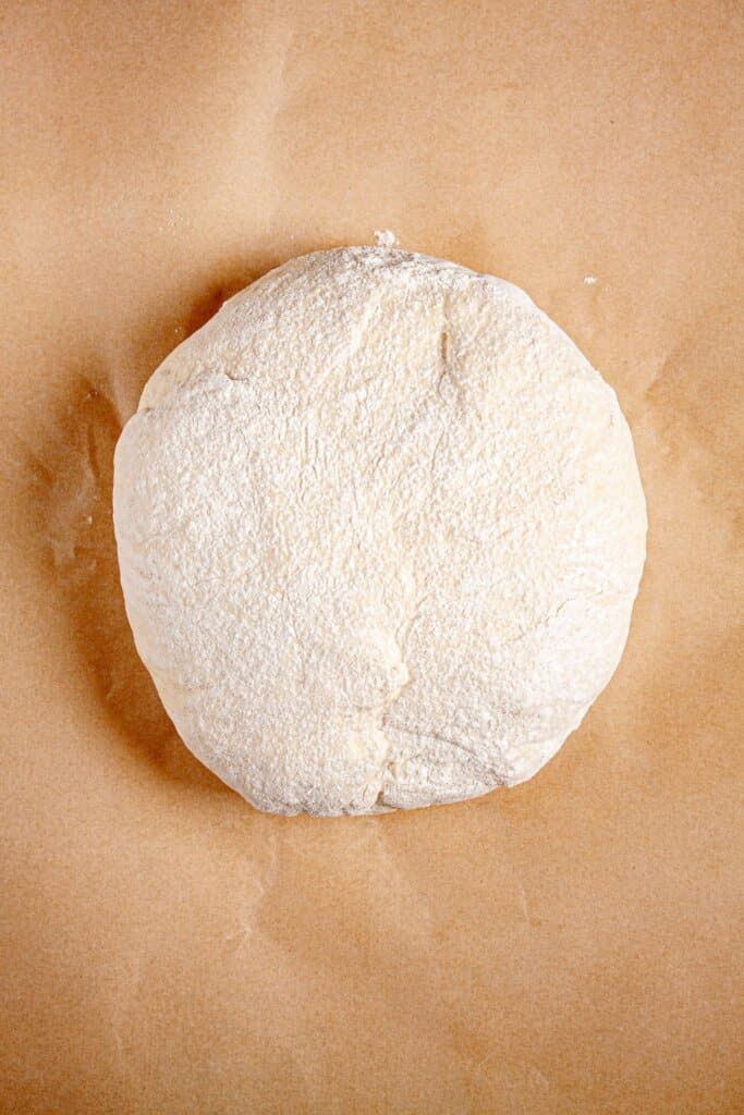 Ball of dough on a piece of parchment paper.