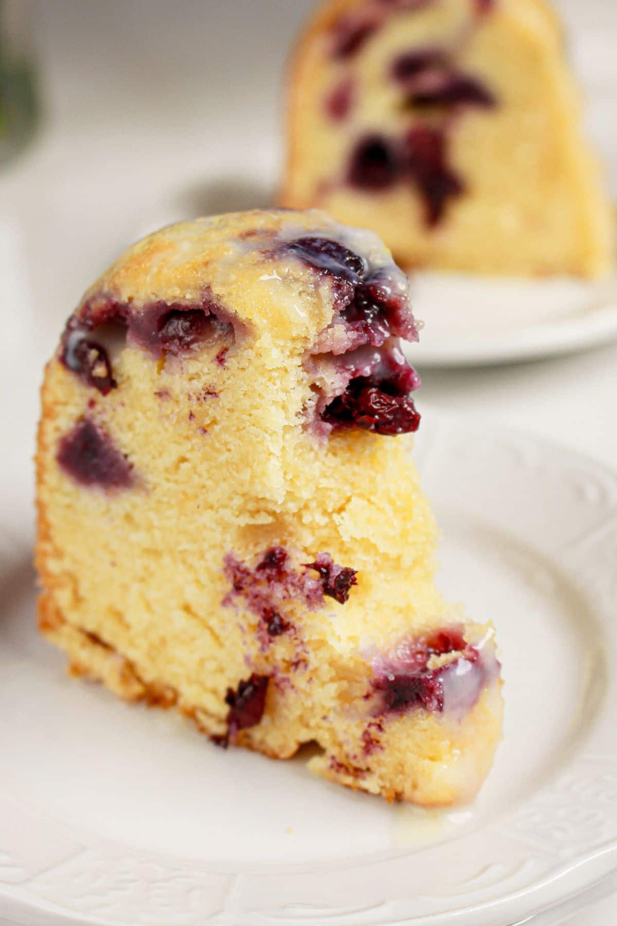 Slice of lemon blueberry bundt cake with a bite missing.