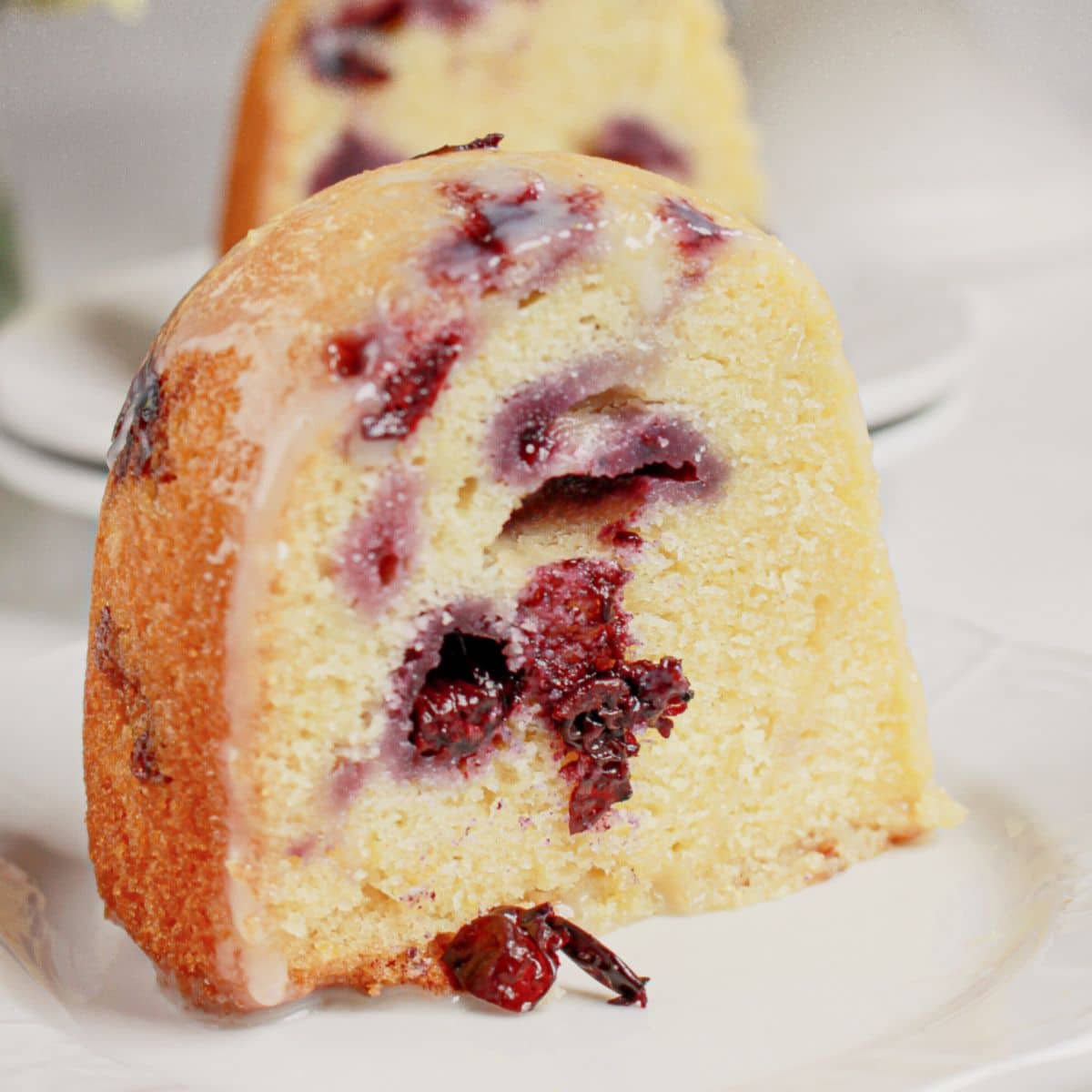 Slice of lemon blueberry bundt cake on a plate.