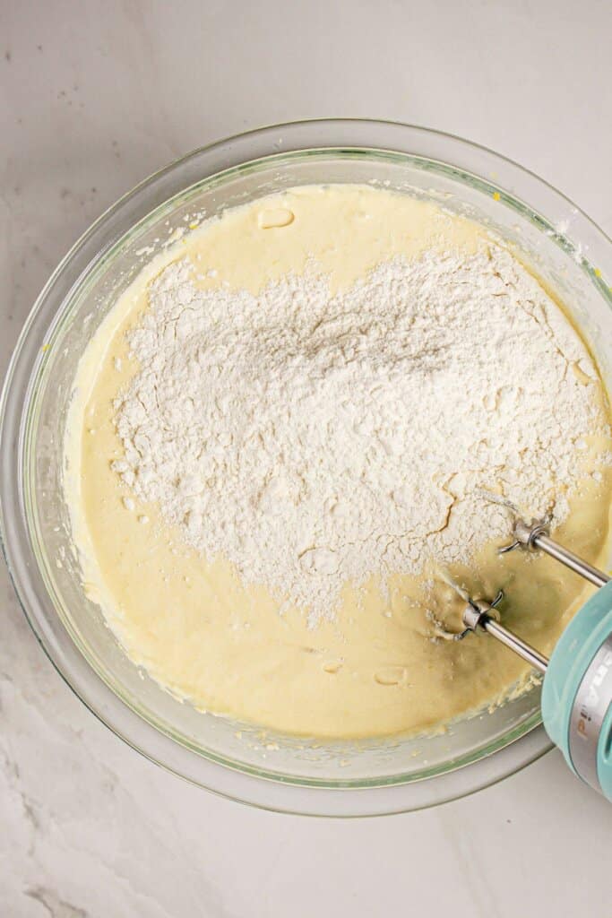 Dry ingredients being mixed into a glass mixing bowl.