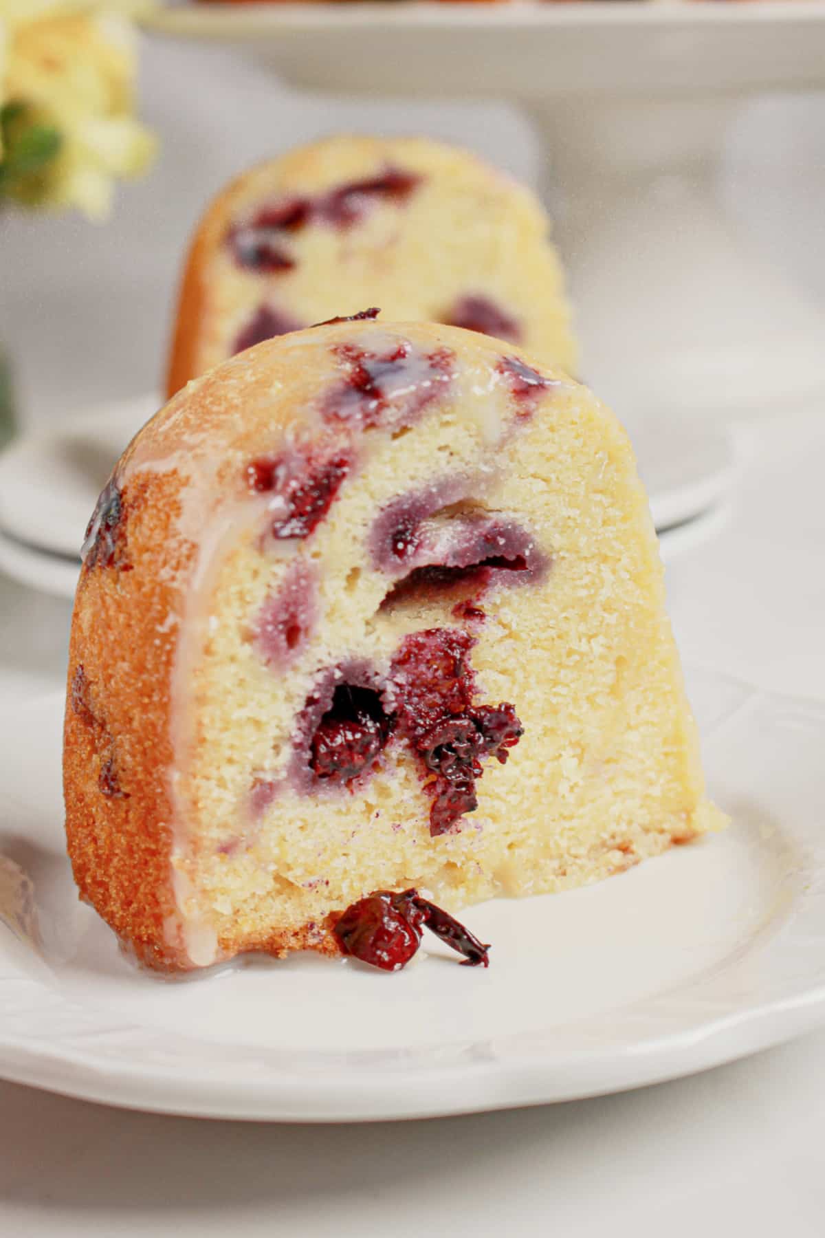 Slice of lemon blueberry bundt cake on a plate.