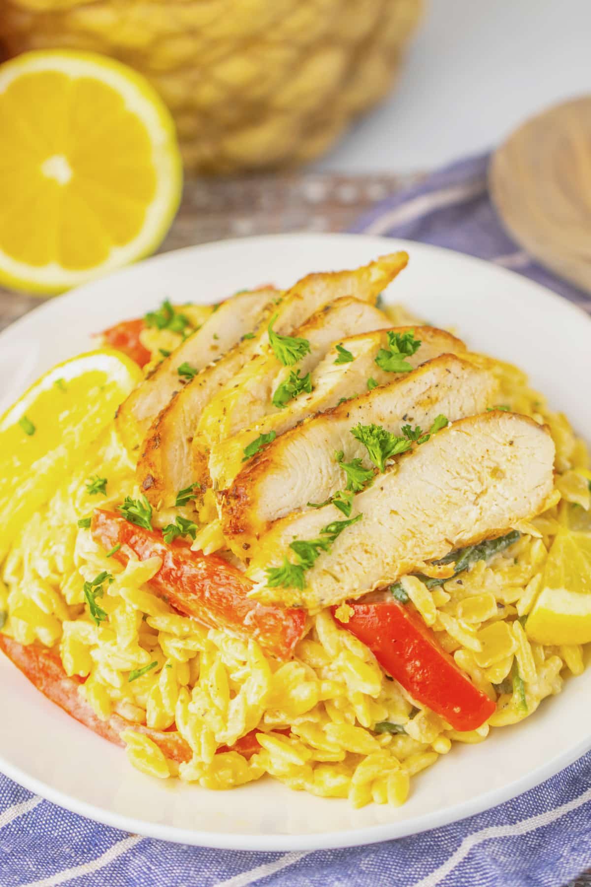 Plate full of lemon chicken orzo on a table.