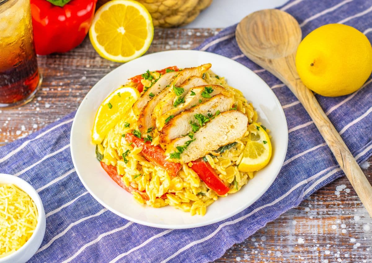 Plate full of lemon chicken orzo on a table.