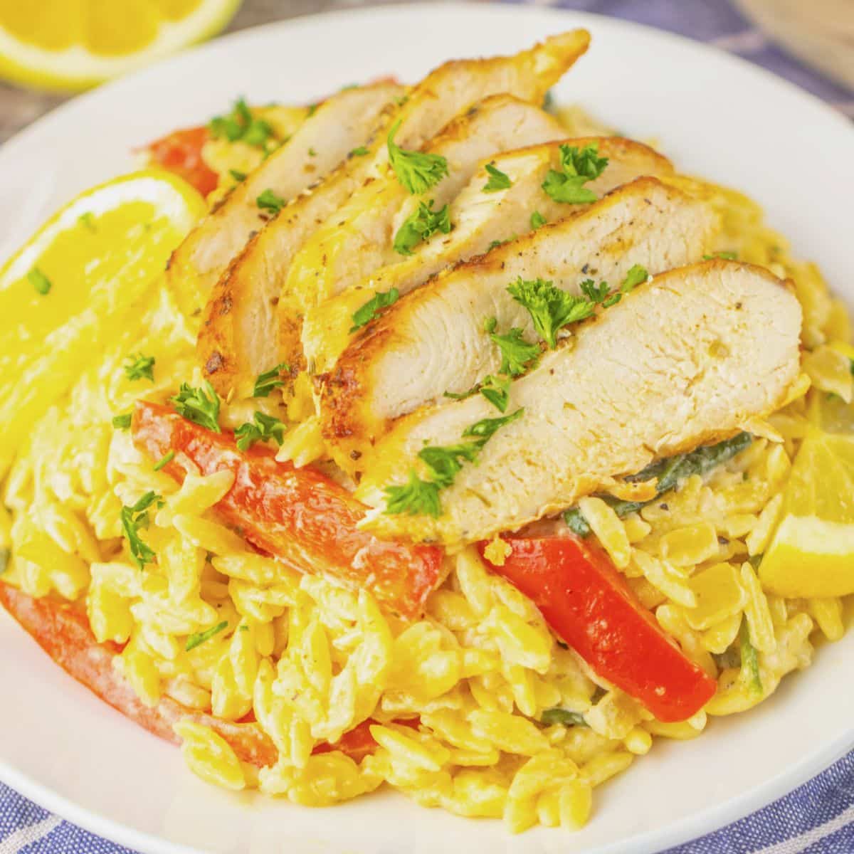 Plate full of lemon chicken orzo on a table.