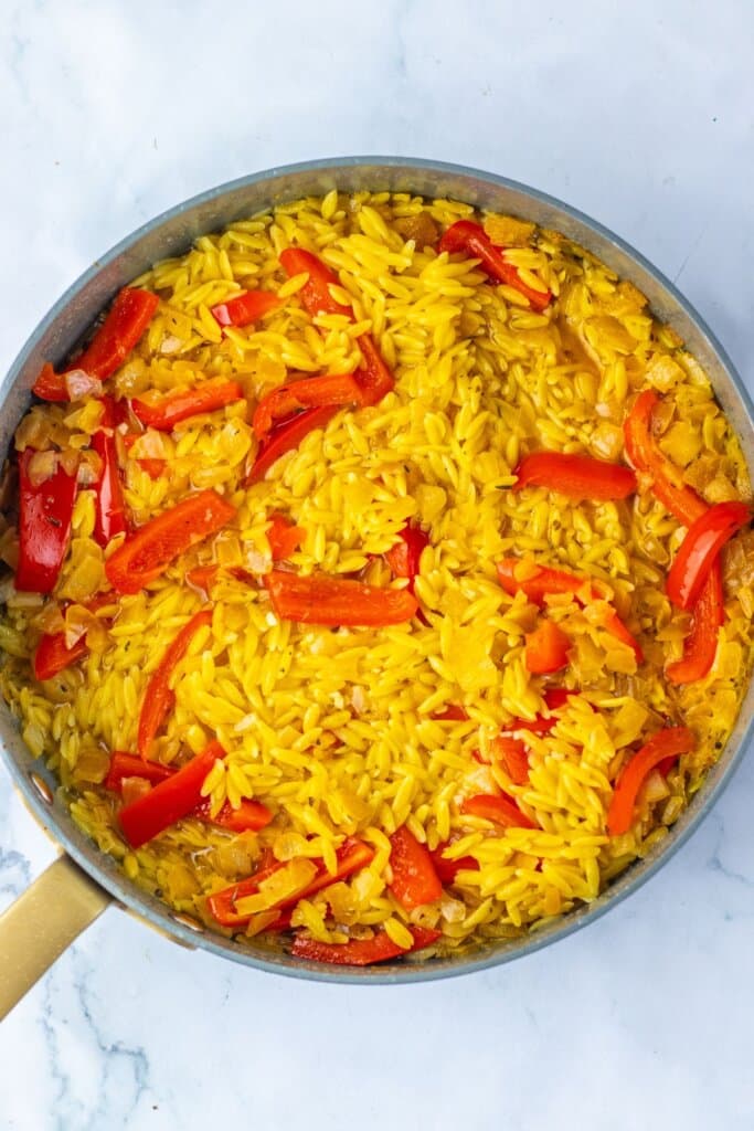 Cooked pasta and peppers in a skillet.
