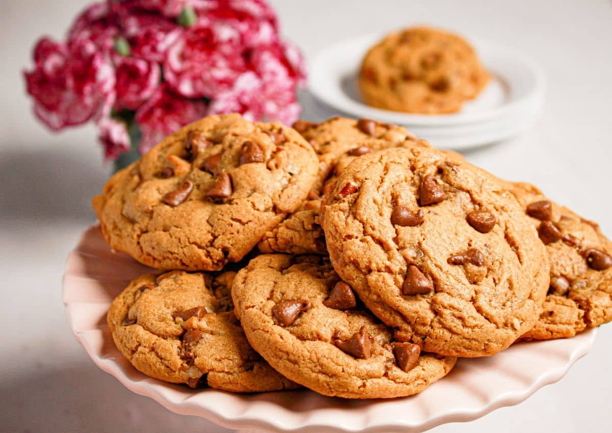 Peanut butter chocolate chip cookies stacked on a cake plate.
