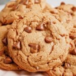 Peanut butter chocolate chip cookies stacked on a cake plate.
