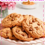 Peanut butter chocolate chip cookies stacked on a cake plate.