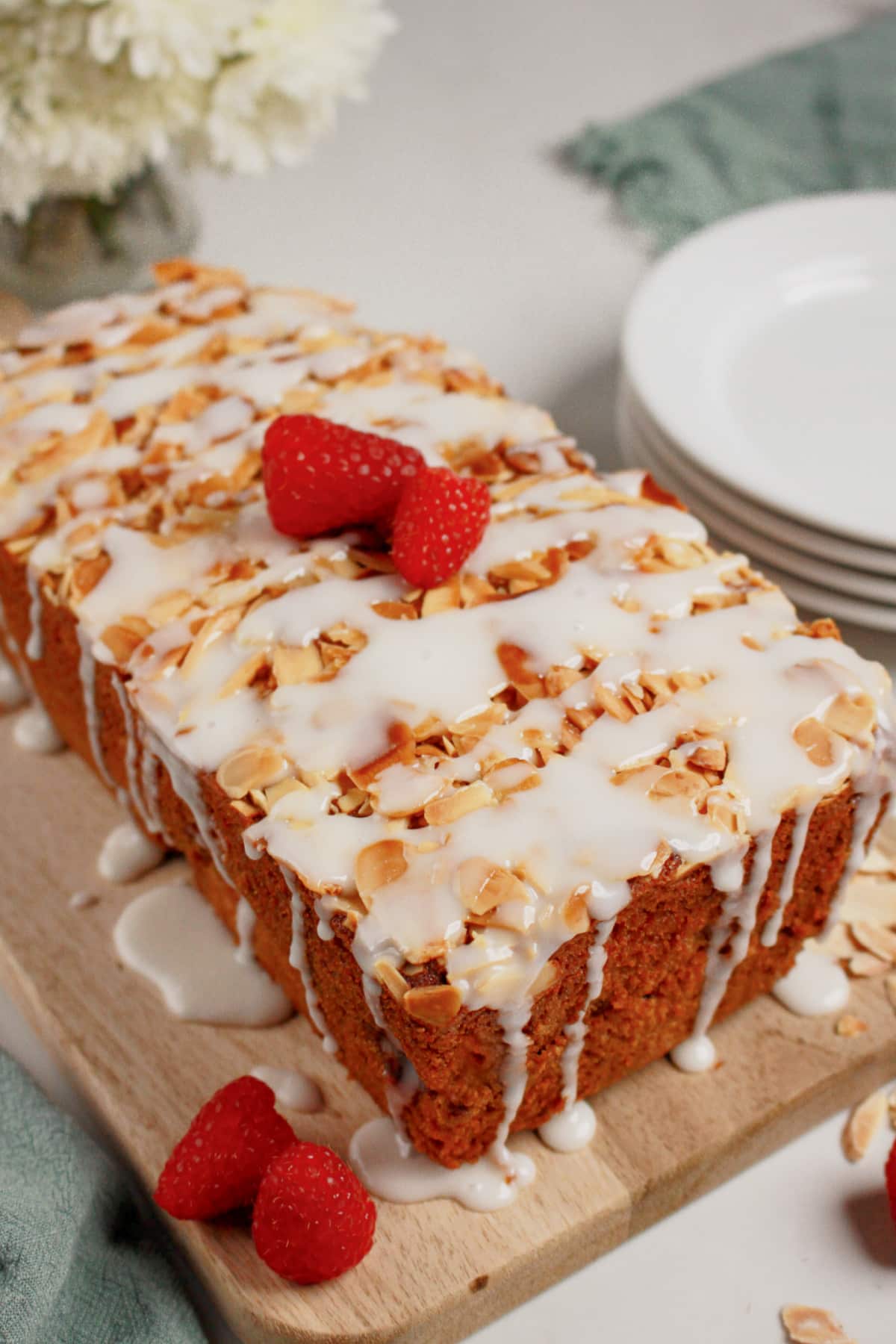 Whole loaf of raspberry lemon bread on a wooden cutting board.