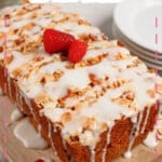 Whole loaf of raspberry lemon bread on a wooden cutting board.