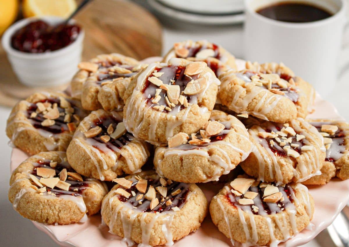 Raspberry Thumbprint Cookies stacked on a plate.