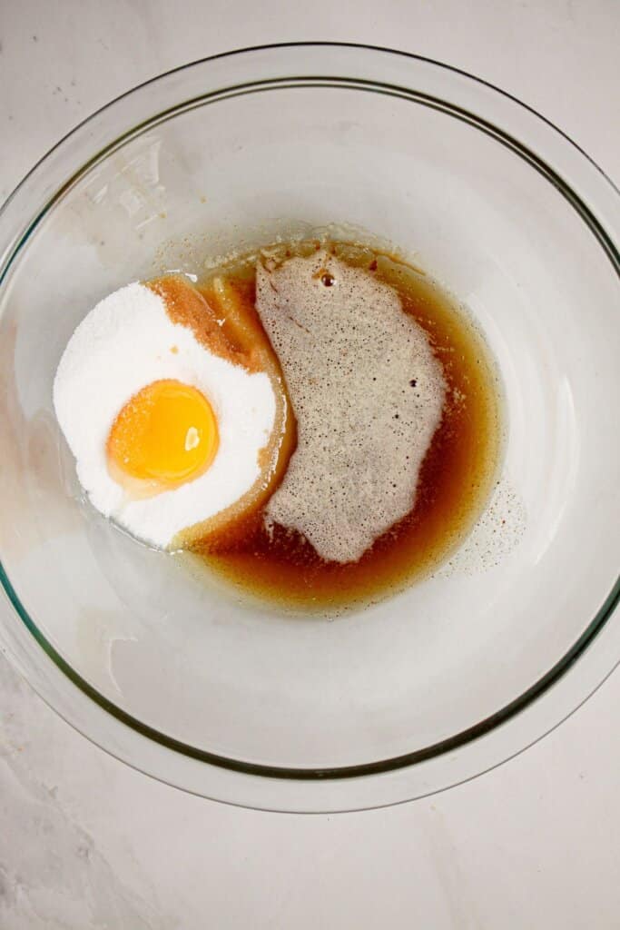 Egg, sugar, and brown butter in a glass mixing bowl.