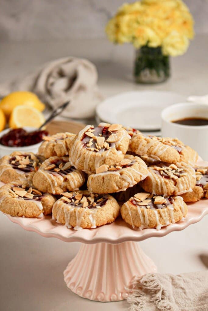 Raspberry Thumbprint Cookies stacked on a plate.